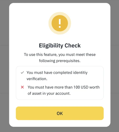 幣安切換「必須使用通行密鑰驗證」時跳出的英文 Eligibility Check 視窗,列出兩項前提條件:已完成身分驗證(打勾)、帳戶資產須超過 100 USD(打叉),底部是黃色 OK 按鈕